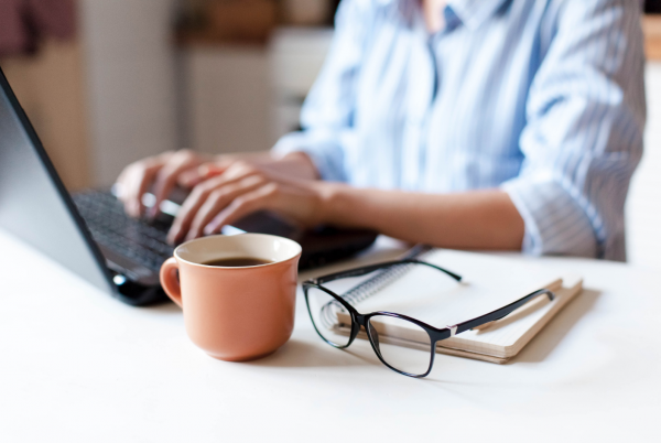 person working at a laptop with a coffee